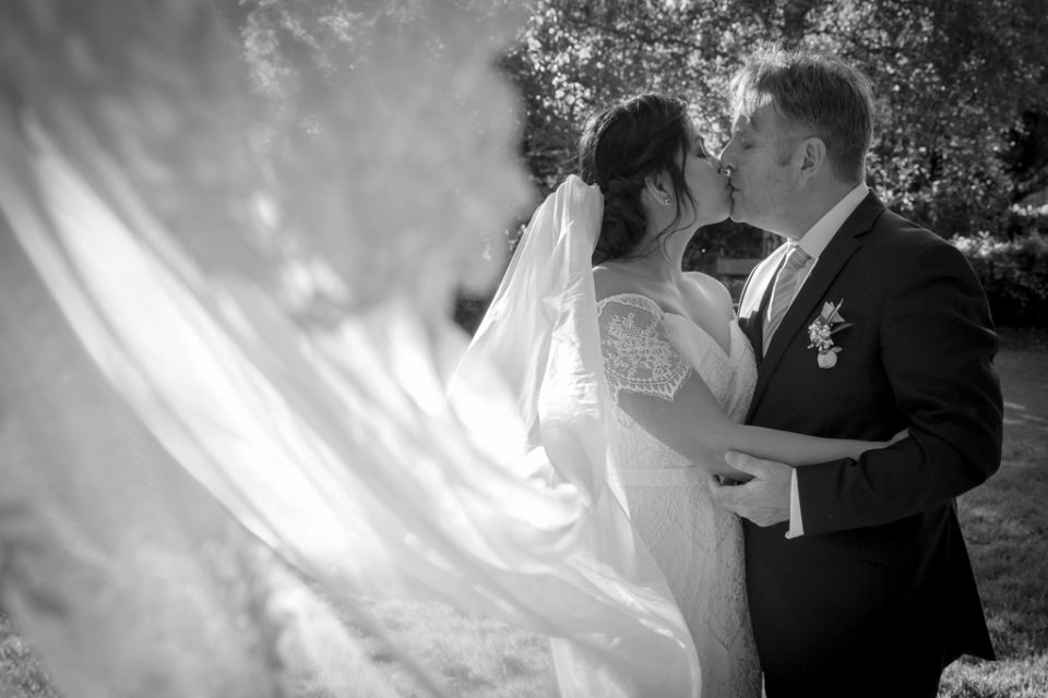 wedding-photography-ballarat-infocus-bride-groom-kissing-veil-bridedress-romance-glamour-flyingveil-holding-together-gardens-wedding